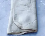 Fold ⅓ af dejen indover fyldet fra den korteste ende. Fold igen ⅓ af dejen indover, så dejpladen nu er i 3 lag.